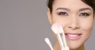 Cute lady with brushes in front of face