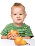 Cute little boy is eating pear royalty free stock photography Cute little boy is eating pear royalty free stock photography