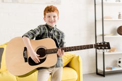 cute little boy holding acoustic guitar and smiling stock photo cute little boy holding acoustic guitar and smiling stock photo