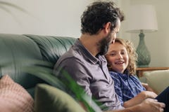 Little boy and his father talking together on their sofa royalty free stock image Little boy and his father talking together on their sofa royalty free stock image