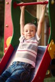 Cute little boy about to take a ride on a slide royalty free stock photography Cute little boy about to take a ride on a slide royalty free stock photography