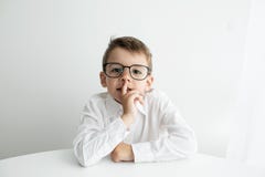 Cute little boy using laptop while doing homework against white background royalty free stock images Cute little boy using laptop while doing homework against white background royalty free stock images