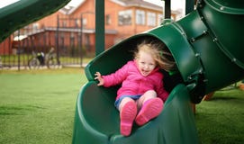 Cute little girl having fun on outdoor playground stock image Cute little girl having fun on outdoor playground stock image