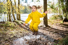 Cute little girl jumping in muddy puddle Stock Photography Cute little girl jumping in muddy puddle Stock Photography