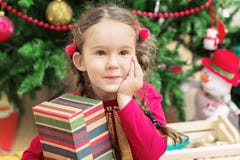 Cute Little Girl Near Beautiful Christmas Tree With A Gift Stock Images