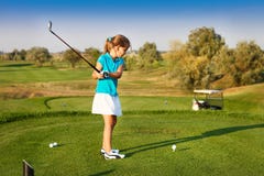 Cute little girl playing golf on a field outdoor