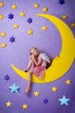 Cute little girl sitting on a big moon Stock Images Cute little girl sitting on a big moon Stock Images
