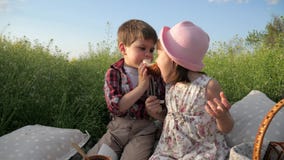 Cute little kids sharing bread, boy feeds girl with bakery product, products in picnic baske, children having fun in stock video footage Cute little kids sharing bread, boy feeds girl with bakery product, products in picnic baske, children having fun in stock video footage