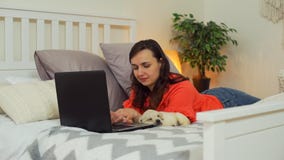 Cute Puppy Sleeping while Woman Working on Laptop