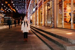 Cute scared lost little girl in a big city in the evening in winter stock photo Cute scared lost little girl in a big city in the evening in winter stock photo