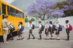 Cute schoolchildren waiting to get on school bus