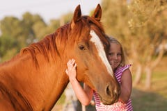 Cute smilling little girl with her handsome horse