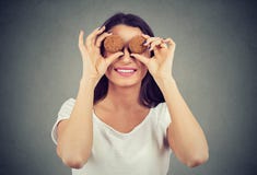 Cute woman holding cookies in front of her eyes and smiling happily stock photography Cute woman holding cookies in front of her eyes and smiling happily stock photography