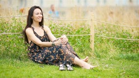 Cute woman relaxing in the park outdoors stock video footage Cute woman relaxing in the park outdoors stock video footage