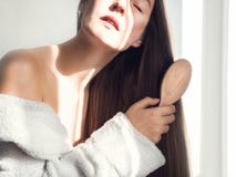 Cute, young woman combing her hair royalty free stock photos Cute, young woman combing her hair royalty free stock photos