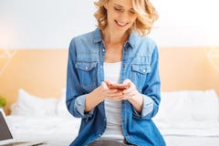 Cute young woman smiling while reading pleasant messages royalty free stock photography Cute young woman smiling while reading pleasant messages royalty free stock photography