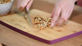 Cutting fresh walnuts - preparing a cake - close up. stock footage Cutting fresh walnuts - preparing a cake - close up. stock footage