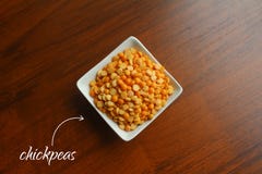 Cuvette blanche avec des grains des pois secs jaunes sur une table en bois, vue supérieure photographie stock libre de droits Cuvette blanche avec des grains des pois secs jaunes sur une table en bois, vue supérieure photographie stock libre de droits