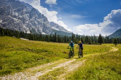 Cycling couple with bikes on track, Cortina d`Ampezzo, Dolomites royalty free stock photo Cycling couple with bikes on track, Cortina d`Ampezzo, Dolomites royalty free stock photo