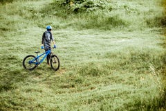 Cyclist with bicycle on the green meadow stock photo Cyclist with bicycle on the green meadow stock photo