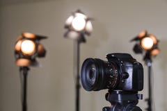 Cyfrowego SLR kamera i trzy światła reflektorów z Fresnel obiektywami Ręczny wymienny obiektyw dla filmować Zdjęcia Royalty Free Cyfrowego SLR kamera i trzy światła reflektorów z Fresnel obiektywami Ręczny wymienny obiektyw dla filmować Zdjęcia Royalty Free