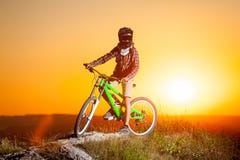 Cyklista z rowerem górskim na wzgórzu w wieczór zdjęcia stock Cyklista z rowerem górskim na wzgórzu w wieczór zdjęcia stock