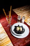 Czarny makaronów Cuttlefish atramentu wciąż życie na drewnianym stole z czerwonymi nieociosanymi tableclothes Puste miejsce z kop zdjęcia royalty free Czarny makaronów Cuttlefish atramentu wciąż życie na drewnianym stole z czerwonymi nieociosanymi tableclothes Puste miejsce z kop zdjęcia royalty free