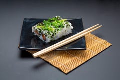 Czarny talerz z amerykan chopsticks i rolkami zdjęcia royalty free Czarny talerz z amerykan chopsticks i rolkami zdjęcia royalty free