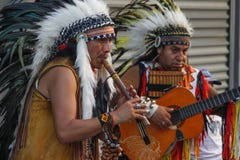 Czerwoni indianów rodowici amerykanie bawić się flet i gitarę w piórkowych pióropuszach zdjęcie stock Czerwoni indianów rodowici amerykanie bawić się flet i gitarę w piórkowych pióropuszach zdjęcie stock