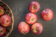 Czerwony dojrzały Appples na ciemnym nieociosanym drewnianym tle z drewnianym koszem, Odg?rny widok zdjęcia stock Czerwony dojrzały Appples na ciemnym nieociosanym drewnianym tle z drewnianym koszem, Odg?rny widok zdjęcia stock