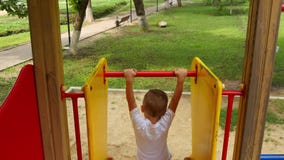 A câmera segue o menino que rola para baixo o monte no campo de jogos Criança feliz que joga no campo de jogos no parque video estoque A câmera segue o menino que rola para baixo o monte no campo de jogos Criança feliz que joga no campo de jogos no parque video estoque