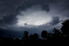 Céu escuro dramático escuro e silhuetas pretas das árvores Tormentoso nós fotografia de stock Céu escuro dramático escuro e silhuetas pretas das árvores Tormentoso nós fotografia de stock
