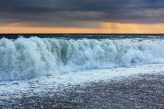 Côte avec des ondes ; le soleil est apparu par des nuages Photo libre de droits Côte avec des ondes ; le soleil est apparu par des nuages Photo libre de droits
