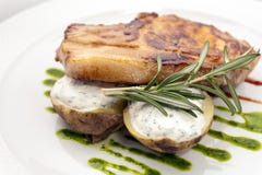 Côtelette de porc avec des pommes de terre bourrées de la sauce crémeuse à sauce, à romarin et à kiwi d'un plat blanc image stock Côtelette de porc avec des pommes de terre bourrées de la sauce crémeuse à sauce, à romarin et à kiwi d'un plat blanc image stock