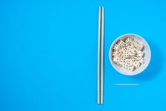 D?coupe dans une cuvette blanche avec des baguettes sur le fond bleu photo libre de droits D?coupe dans une cuvette blanche avec des baguettes sur le fond bleu photo libre de droits