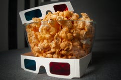 3D glasses and cheesy popcorn lie in a glass plate on a gray bed royalty free stock image 3D glasses and cheesy popcorn lie in a glass plate on a gray bed royalty free stock image