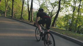 D?nner athletischer Radfahrer, der auf Rennrad im Park absteigt Radfahrer, der die schwarze Ausstattung f?hrt schwarzes Fahrrad t stock video D?nner athletischer Radfahrer, der auf Rennrad im Park absteigt Radfahrer, der die schwarze Ausstattung f?hrt schwarzes Fahrrad t stock video