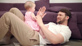 Dad with baby playing hands. Smiling father and toddler girl play with hands stock video footage Dad with baby playing hands. Smiling father and toddler girl play with hands stock video footage