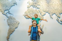 Dad and son on the background of a world map with an airplane in his hands. Travel concept stock photography Dad and son on the background of a world map with an airplane in his hands. Travel concept stock photography