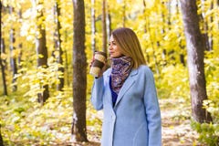 Daling, aard, mensenconcept - de jonge donkerbruine vrouw drinkt koffie in de herfstpark stock afbeeldingen Daling, aard, mensenconcept - de jonge donkerbruine vrouw drinkt koffie in de herfstpark stock afbeeldingen