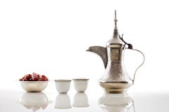 A dallah, a metal pot for making Arabic coffee with a bowl of dried dates royalty free stock photography A dallah, a metal pot for making Arabic coffee with a bowl of dried dates royalty free stock photography