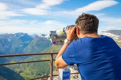 Dalsnibba, Noruega - 26 06 2018: Homem que olha nos binóculos no ponto de vista Dalsnibba, vista do fiorde de Gejranger, Noruega imagens de stock Dalsnibba, Noruega - 26 06 2018: Homem que olha nos binóculos no ponto de vista Dalsnibba, vista do fiorde de Gejranger, Noruega imagens de stock
