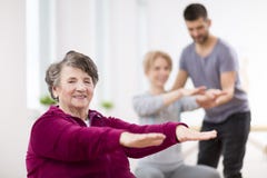 Dame supérieure s'exerçant pendant la physiothérapie de groupe au centre de réhabilitation photographie stock libre de droits Dame supérieure s'exerçant pendant la physiothérapie de groupe au centre de réhabilitation photographie stock libre de droits