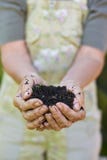 Dame âgée avec une poignée de compost photo libre de droits Dame âgée avec une poignée de compost photo libre de droits