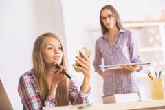 Dames de sourire appliquant le maquillage image stock Dames de sourire appliquant le maquillage image stock