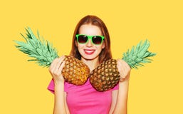 Dana den nätta le kvinnan för ståenden och ananas två i solglasögon över guling arkivfoto Dana den nätta le kvinnan för ståenden och ananas två i solglasögon över guling arkivfoto