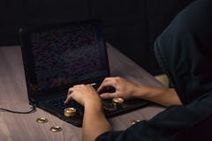 Hooded hacker using laptop to steal bitcoin royalty free stock photos Hooded hacker using laptop to steal bitcoin royalty free stock photos
