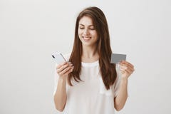 Dank aan haar bank kocht zij nieuwe telefoon Portret van tevreden en geconcentreerde aantrekkelijke smartphone van de vrouwenhold royalty-vrije stock afbeeldingen Dank aan haar bank kocht zij nieuwe telefoon Portret van tevreden en geconcentreerde aantrekkelijke smartphone van de vrouwenhold royalty-vrije stock afbeeldingen