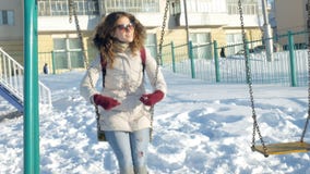Dans la fille de parc d'hiver sur une oscillation Dans la fille de parc d'hiver sur une oscillation