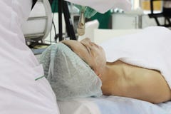 Dans le salon de beaut? une jeune femme fait un ?pluchage sur son visage images libres de droits Dans le salon de beaut? une jeune femme fait un ?pluchage sur son visage images libres de droits
